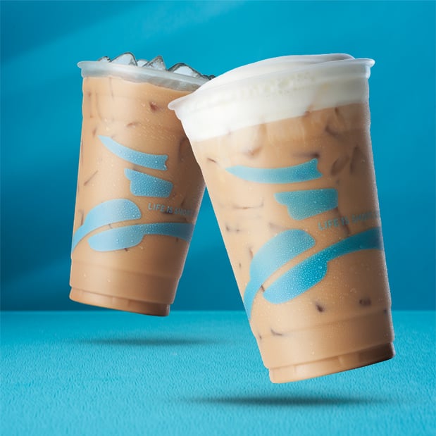 Two latte beverages on a blue backgroun