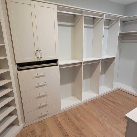 A white walk-in closet with dividers and shelves for organized storage.