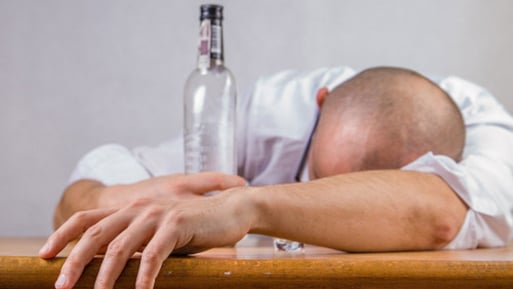 Photo of man with empty alcohol bottle