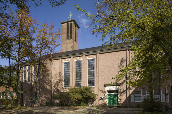 Das Kirchengebäude von Bäumen umringt.