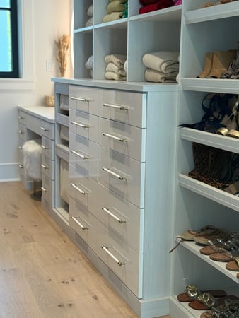Custom walk-in closet with hi-gloss drawer fronts and built-in vanity.