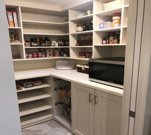 Functional pantry trimmed to ceiling with wide and functional countertop, shaker doors and baskets