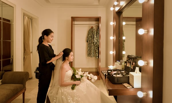 挙式前のヘアメイクをする新婦とヘアメイクスタッフ