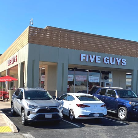 Exterior photograph of the entrance to the Five Guys restaurant at 1201 Marina Boulevard in San Leandro, California.