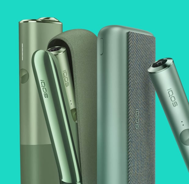 IQOS ILUMA uređaji na tirkiznoj pozadini