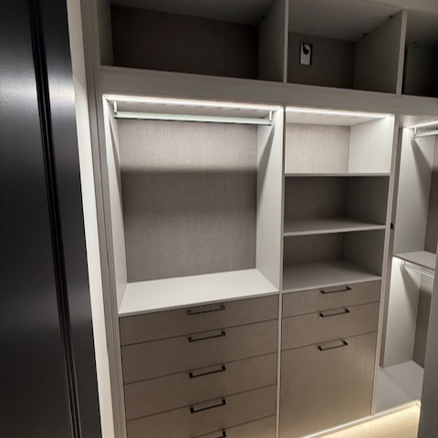 Children’s closet in Sunset Mist with Corsican Weave backing and drawer faces, featuring suspended poles, graphite accessories, and integrated lighting for a playful yet organized storage solution.