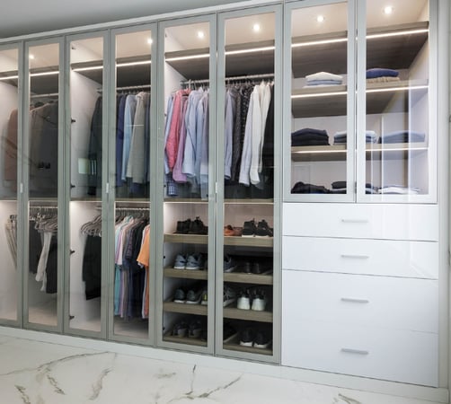 Luxurious white and silver walk-in closet custom built by California Closets Nassau County, New York