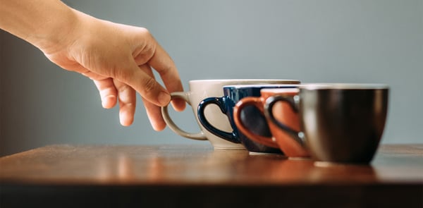 Man reaches for coffee, a trigger for tinnitus in some.
