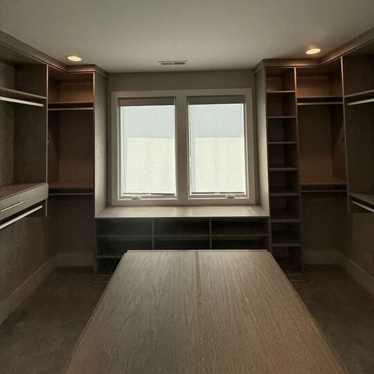 Wilmington - Custom closets - Walk-in closet with wood grain finish, recessed lighting, and natural light from windows.