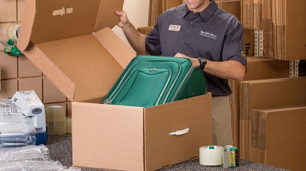 Cajas De Cartón Para Envíos. Varios Paquetes Están En Una Fila. Están  Iluminados Con Luz De Neón. Concepto - Preparación Y Envío De Paquetes.  Cajas De Cartón Como Símbolo Del Envío Postal.