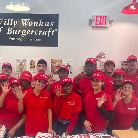 Employees pose for a photograph inside the restaurant ahead of the reopening of the Five Guys in Worcester, Massachusetts. The location had been closed for a month for remodeling.