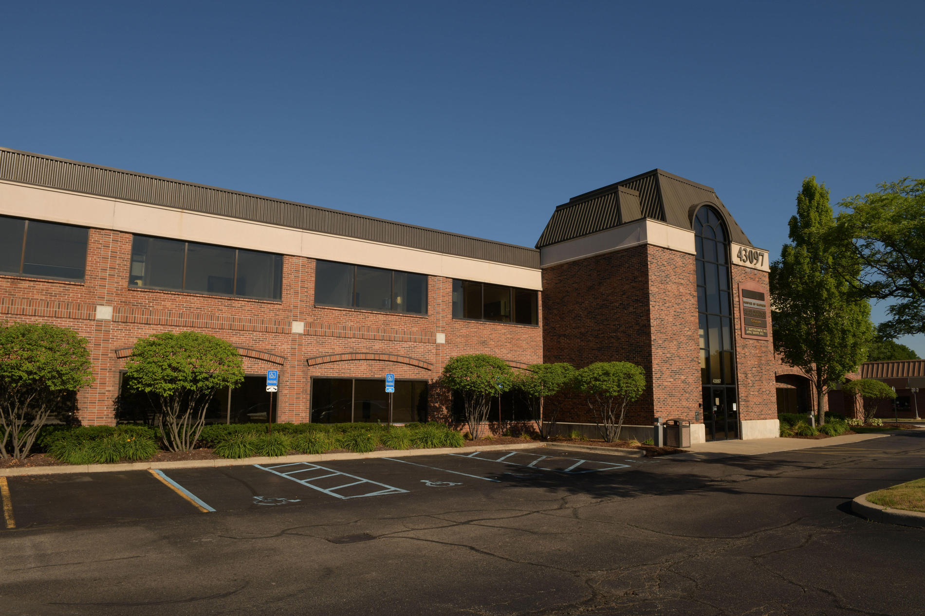 A photo of a 2-story brick office building at 43097 Woodward Ave. in Bloomfield, Michigan.