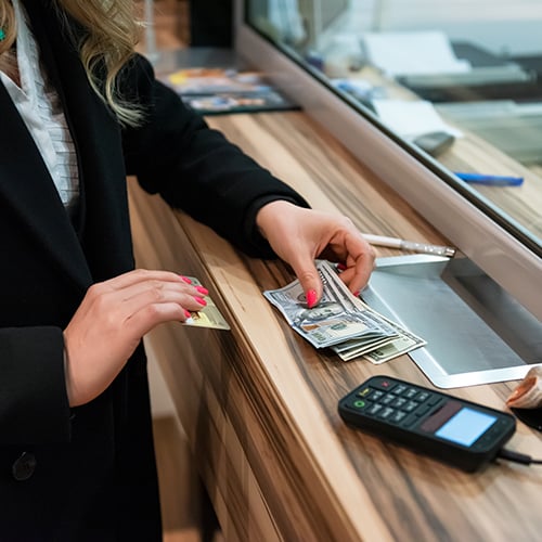 woman places cash on counter