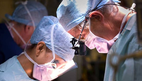 Surgeon operating on patient in theatre