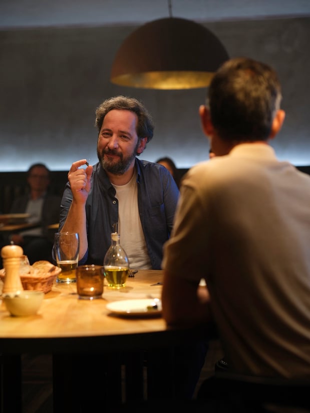 Mann hört klar die Gespräche am Tisch