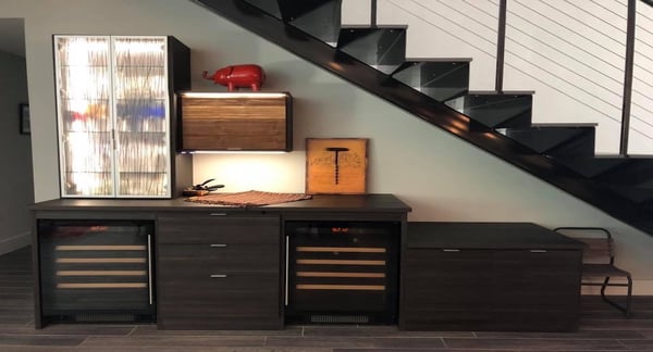 Custom wine bar under the stairs with fridge and aluminum frame doors