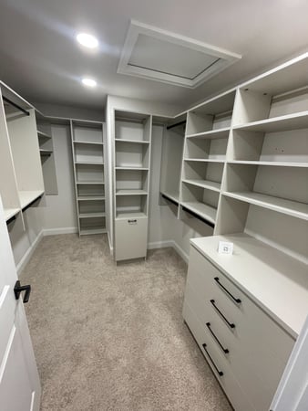 Custom Walk in closet with a light, attic access, and a countertop