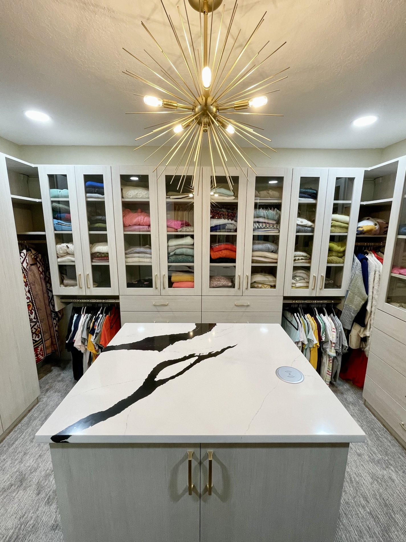 Organized walk-in closet with clothes and drawers