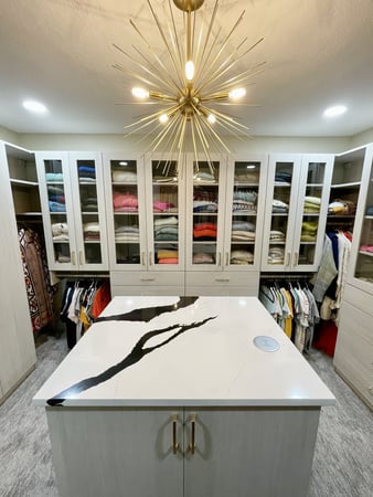Organized walk-in closet with clothes and drawers