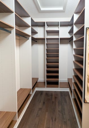 Walk in closet designed in contrasting colours with long hanging and open shelving.