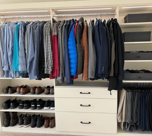 Bedroom closet with hanging space, storage drawers, and shelving.