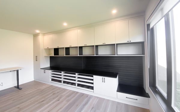 Craft room storage with open shelving and cubbies, slatwall for organizing tools, and closed storage.