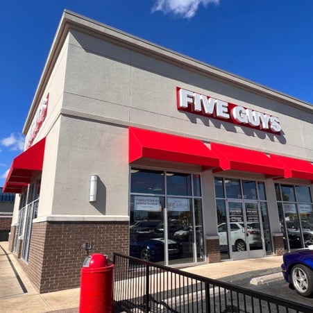 Exterior photograph of the Five Guys restaurant at 2145 Interstate Drive in Opelika, Alabama.