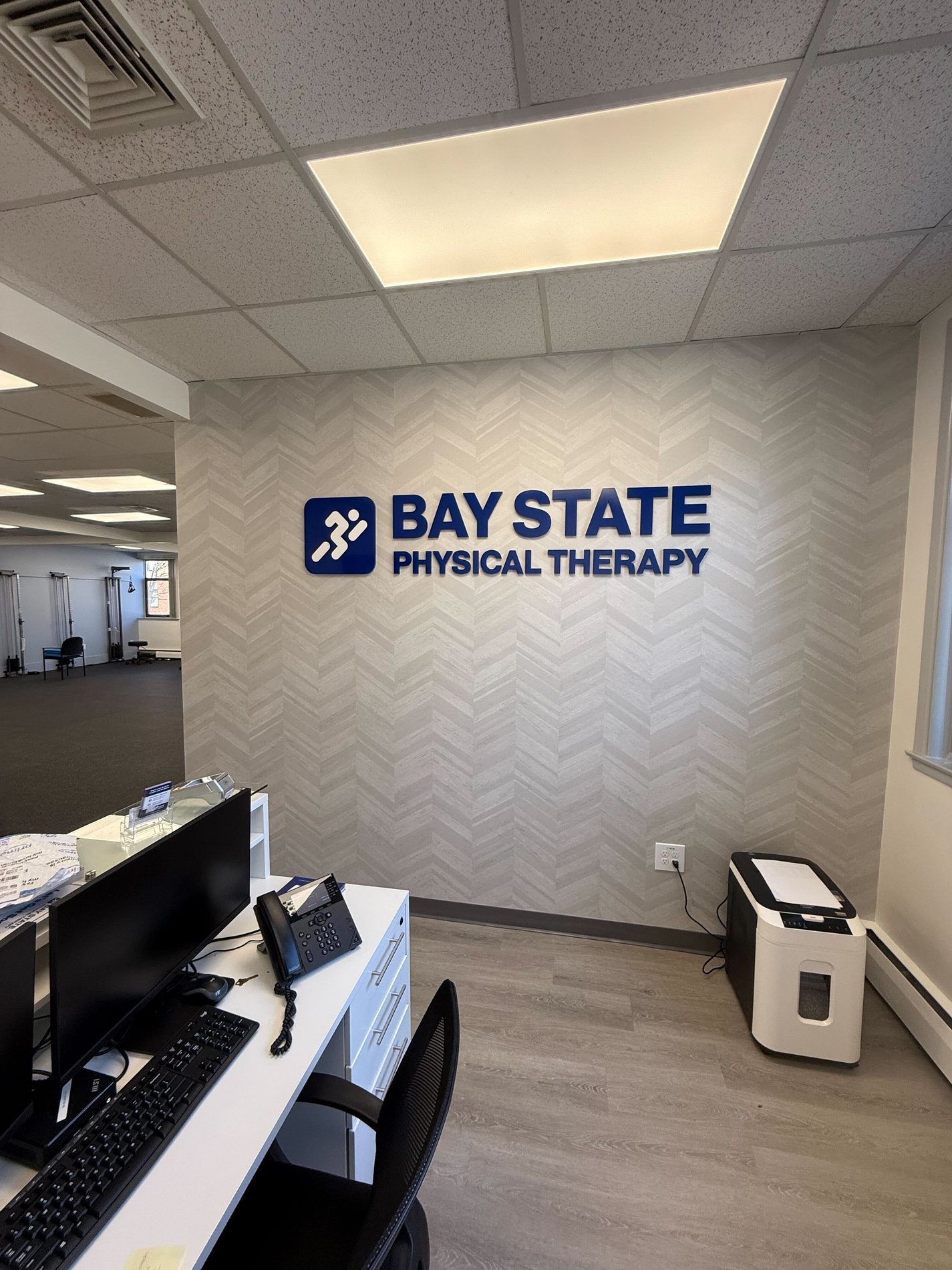 Inside Bay State Physical Therapy clinic, Bay State logo on wall.