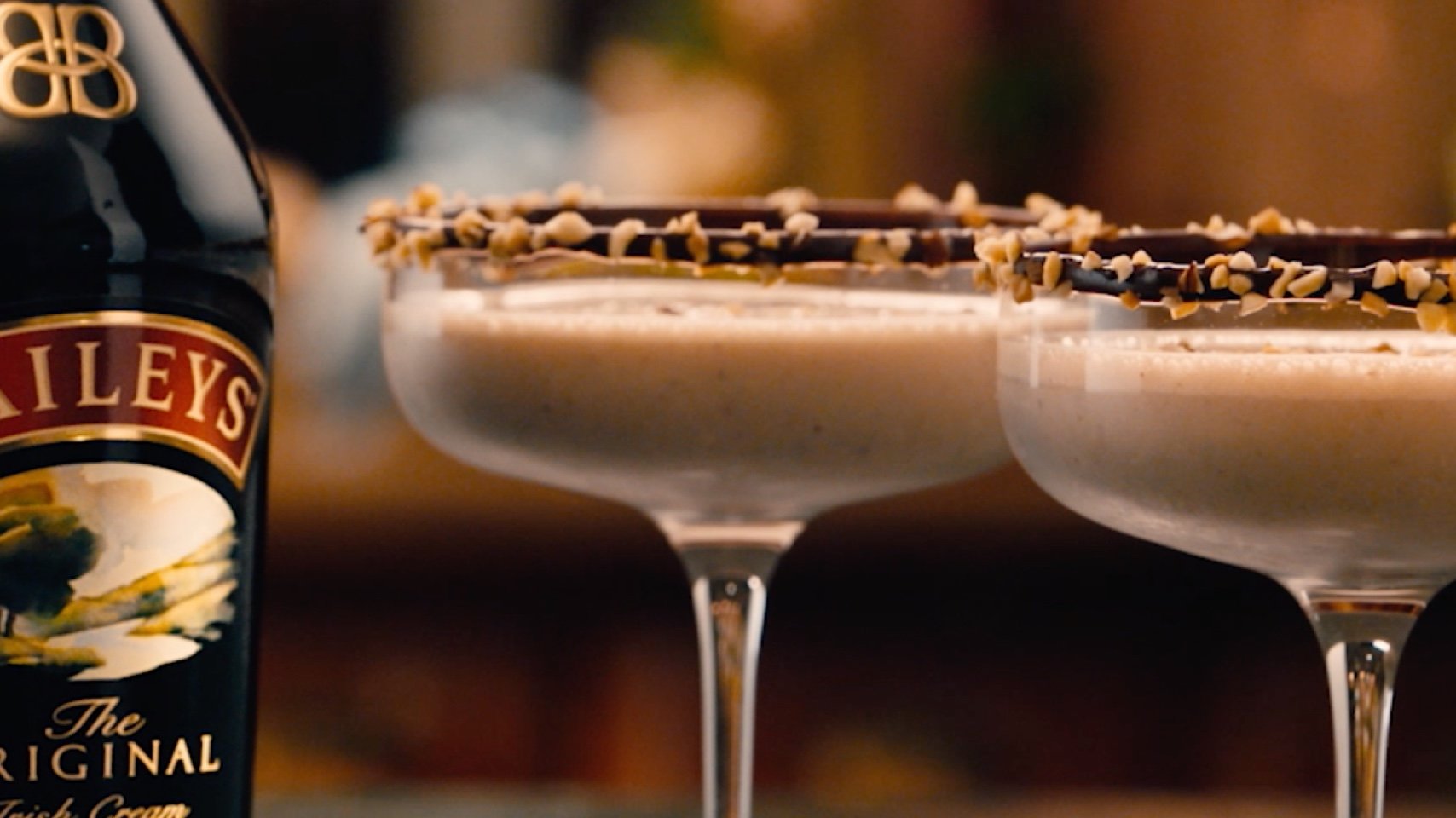 Cocktail glasses with Baileys-infused cocktail and melted chocolate with hazelnuts