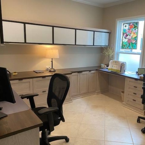 A double desk with wrap-around drawers and floating cabinets provides a stylish and functional workspace.