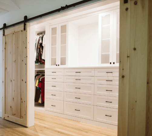Img 5 California Closets Hudson Valley NY White Walk in Closet with White Drawers and Black Handles with Frosted Glass Doors, Vanity, Hanging areas, and Custom Shelving