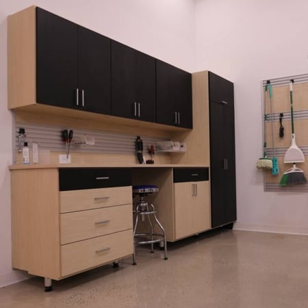 A well-organized garage with cabinets, drawers, and a wall-mounted hook organizer for all your tools and gear.