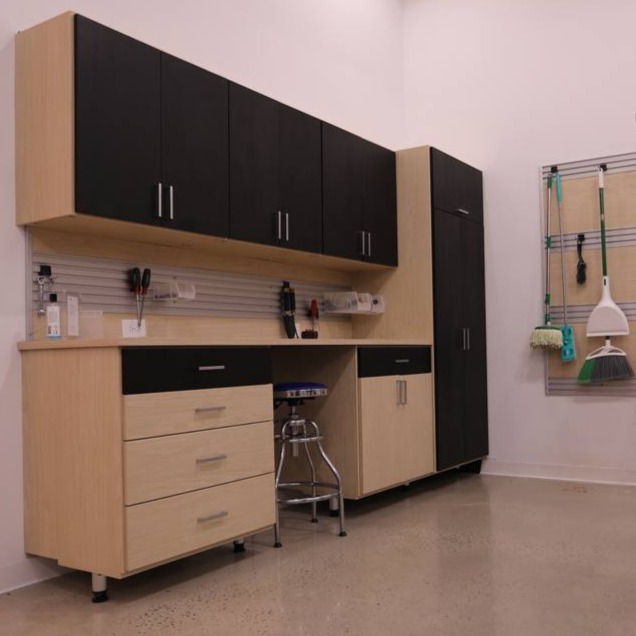 A well-organized garage with cabinets, drawers, and a wall-mounted hook organizer for all your tools and gear.