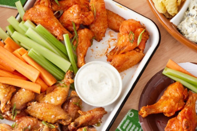 platter of chicken wings and veggies on a table
