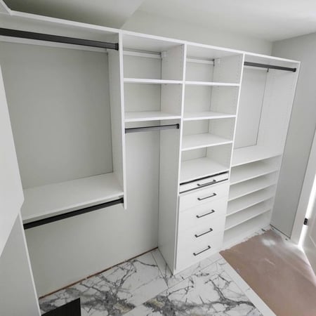 A white walk-in closet, designed with multiple shelves.