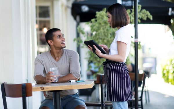 Man using WiFi at a table outside a cafe in Denver, CO