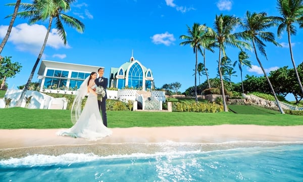 海辺のチャペルで記念撮影をするカップル