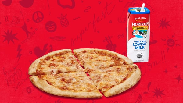 A mini cheese pizza and milk on a red background