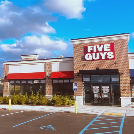 Exterior photograph of the entrance to the Five Guys restaurant at 15 Radcliffe Drive in Moosic, Pennsylvania.