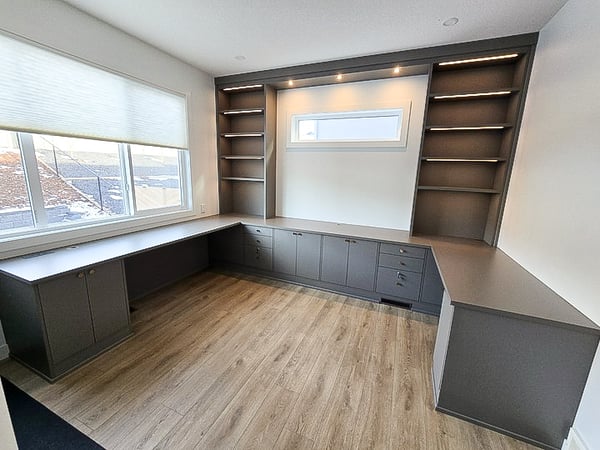 Home office in a gray finish with lower storage, open shelving, and lighting.