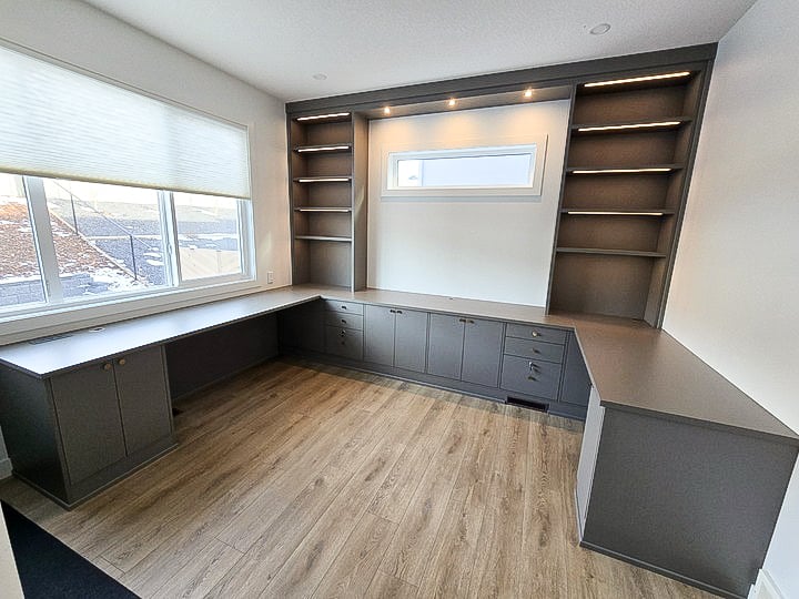Home office in a gray finish with lower storage, open shelving, and lighting.