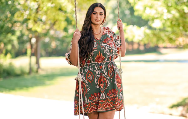 Woman is wearing a plus size short floral dress.