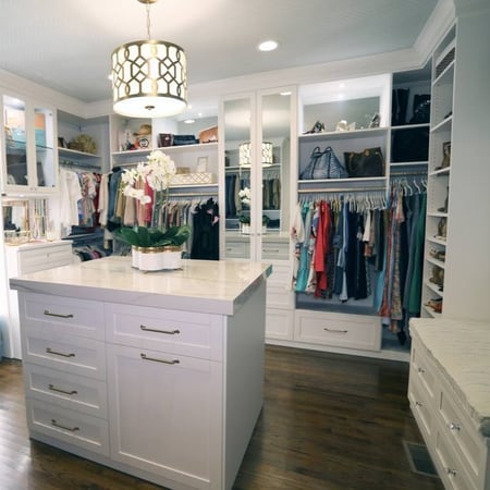 Luxury walk-in closet with an island of drawers in the center of the room