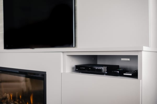 Close up view of a shelf designated for a cable box tucked away beneath the TV