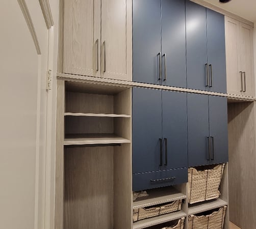 Laundry room with custom cabinets, pull-out baskets, and shelving in two wood finishes by California Closets Pasadena.