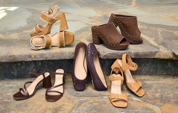 Five pairs of shoes are displayed on stone steps.