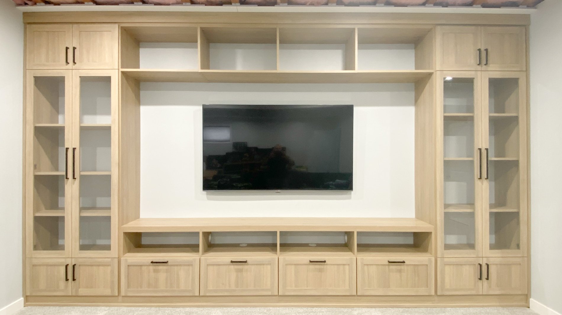 Media centre in a natural finish with glass doors, open cubbies, and closed storage.