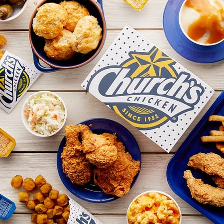 Church's Chicken Box with Fried chicken on a blue plate, Texas Tenders, Mashed potatoes, fries, & Honey-Butter Biscuits