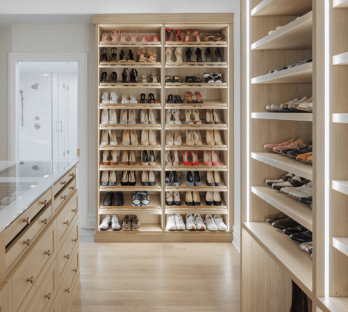 California Closets Rockland, NY Custom Beige Walk in Closet Floor to Ceiling Custom Shoe Shelving LED Partition Lighting adjustable shelving for shoe heights center island with glass countertop jewelry