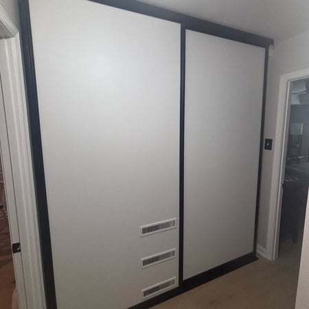 Richmond - Custom closets - closed sliding wall panels concealing storage or utility space with integrated vents